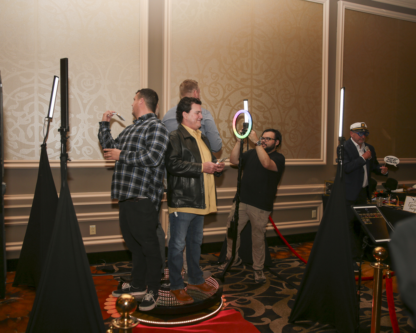 Guests on 360 photo booth platform at corporate event with ring light and LED screens