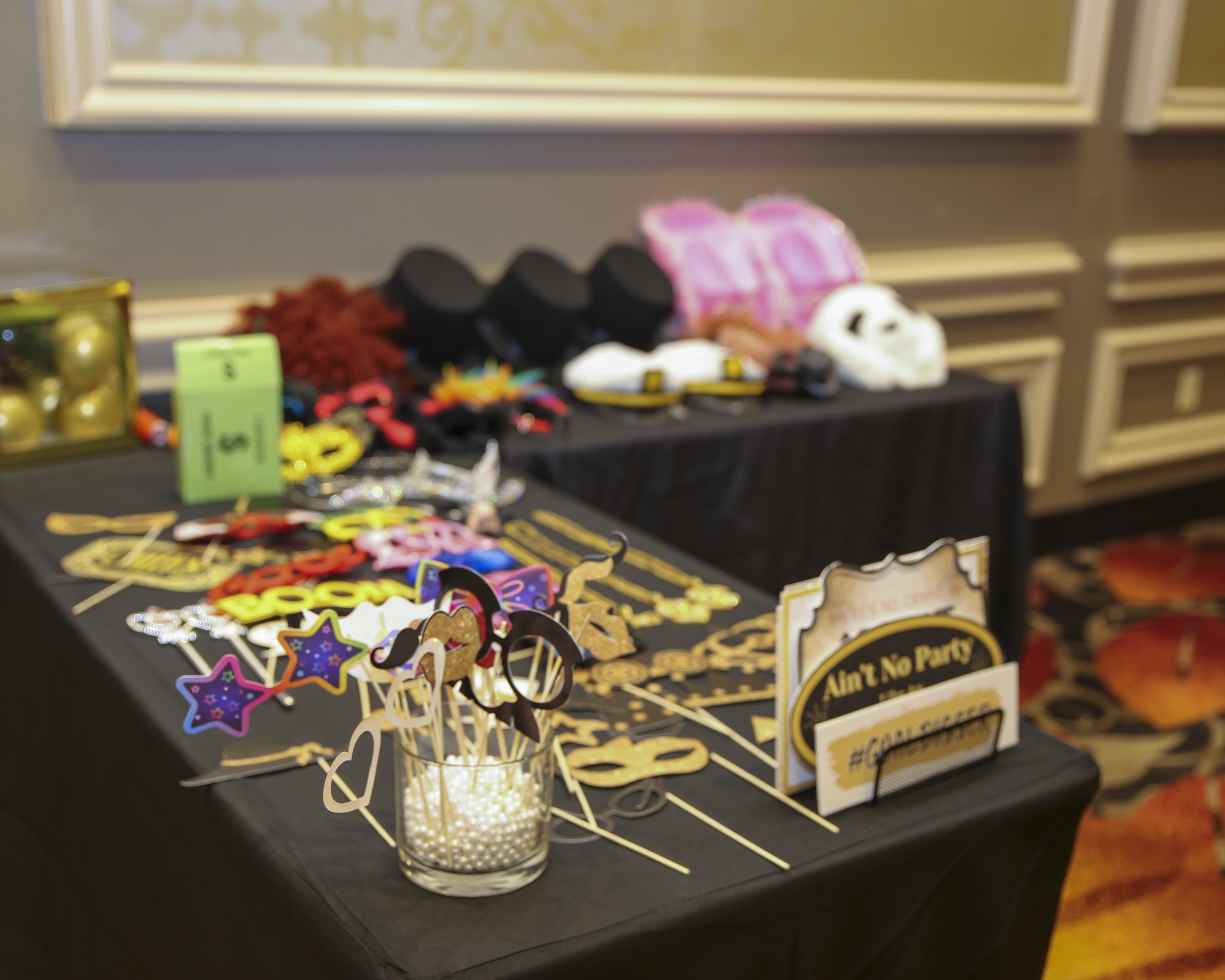 Photo booth props table at corporate awards banquet with masks and accessories