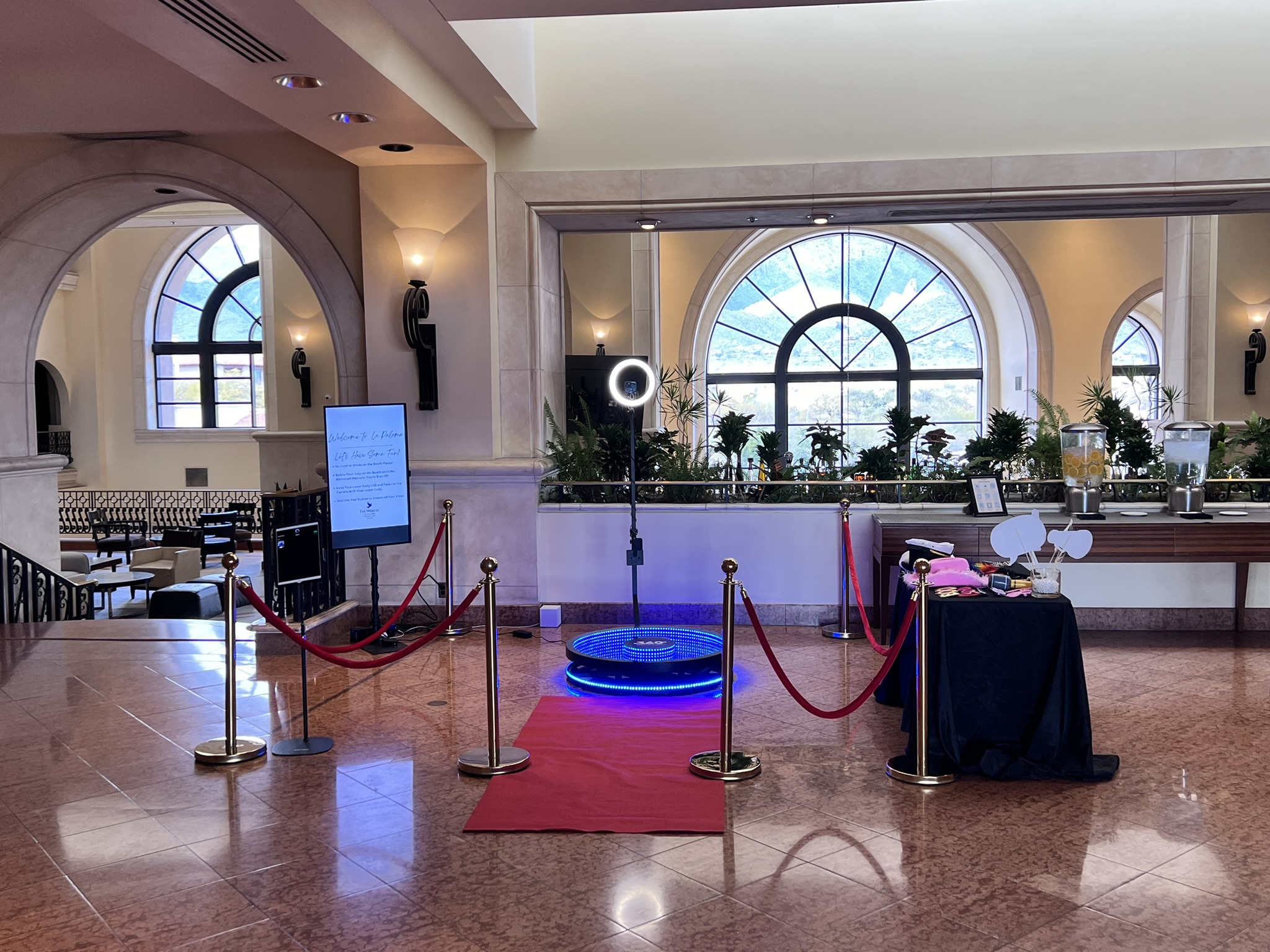 360 booth setup in luxury resort lobby with arched windows and red velvet ropes